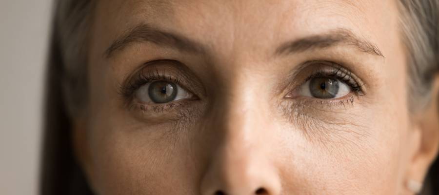 Yakın çekimde, orta yaşlı bir kadının iki gözünü ve çevresindeki yüz detaylarını gösteren görsel; göz irisi, göz kapağı ve kırışıklıklar net şekilde görünmektedir, biyometrik tanıma ve göz analizi uygulamaları için uygundur.
