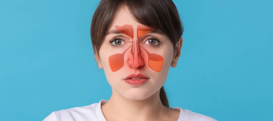 Mavi arka plan önünde duran bir kadının yüzünde, sinüzitli bölgeleri gösteren kırmızı renkte sinüs diyagramı yer almakta. Frontal, maksiller, etmoid ve sfenoid sinüs bölgeleri vurgulanmış.