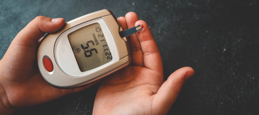 Bir kişinin parmak ucundan kan şekeri ölçümü yaptığı sırada, glukometre cihazında 56 mg/dL değeri görülüyor.