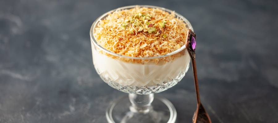 Kavrulmuş tel kadayıf ve Antep fıstığıyla süslenmiş, cam kâsede sunulan geleneksel Türk muhallebisi.