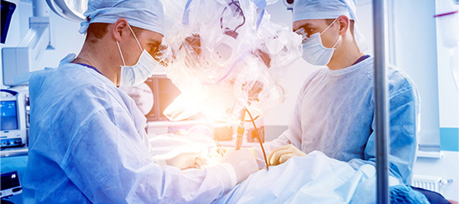 Ameliyathanede cerrahlar, modern tıbbi cihazlar ve mikroskop eşliğinde bir operasyon gerçekleştiriyor.